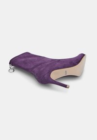 Violetti mokkanahkainen korkokenkä, jossa on terävä kärki, sivuvetoketju pyöreällä nyökillä ja beige pohja, esitettynä kyljellään.