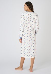 Camisón de manga larga en color crema con un patrón de corazones multicolores, puños acanalados y un diseño hasta la rodilla. Tejido suave y ligero.