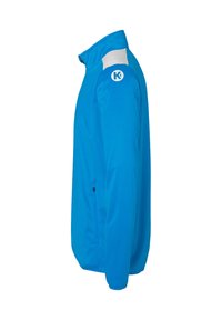 Blå letvægtjakke med høj krave, hvide detaljer på skuldrene, sidelomme med lynlås og logo på overarmen.