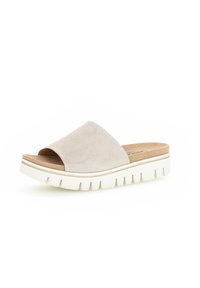 Sandal in suede beige con una larga fascia e una suola piatta bianca spessa con scanalature per una migliore presa. Plantare liscio dal design minimale.