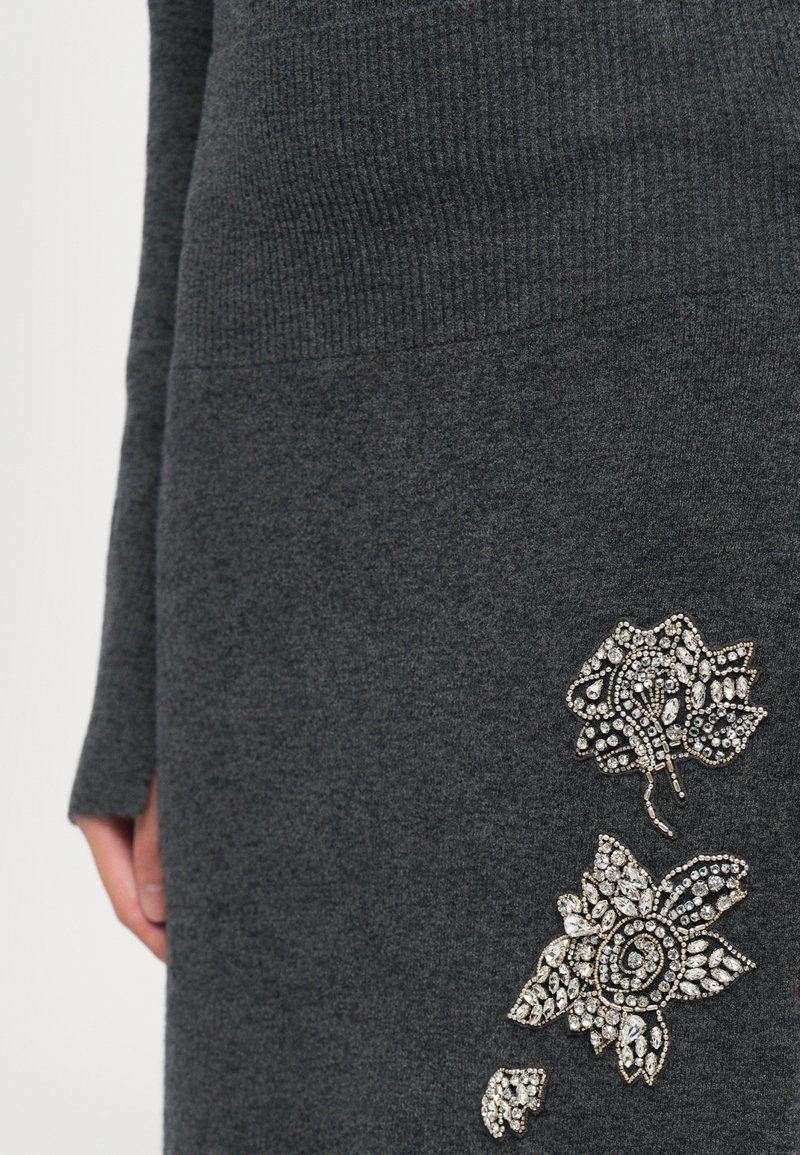Dunkelgraues Strickkleid mit langen Ärmeln und detaillierten floralen Strassverzierungen am rechten Hüftbereich.