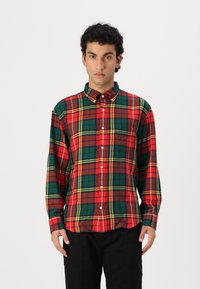 Camicia a maniche lunghe a quadri rossa, verde e gialla con colletto, dotata di taschino frontale e tessuto liscio.