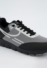 Sportschuh mit einem Obermaterial aus schwarzem und grauem Mesh, kontrastierenden strukturierten Überzügen und einer robusten Gummisohle mit ausgeprägten Profilmustern.