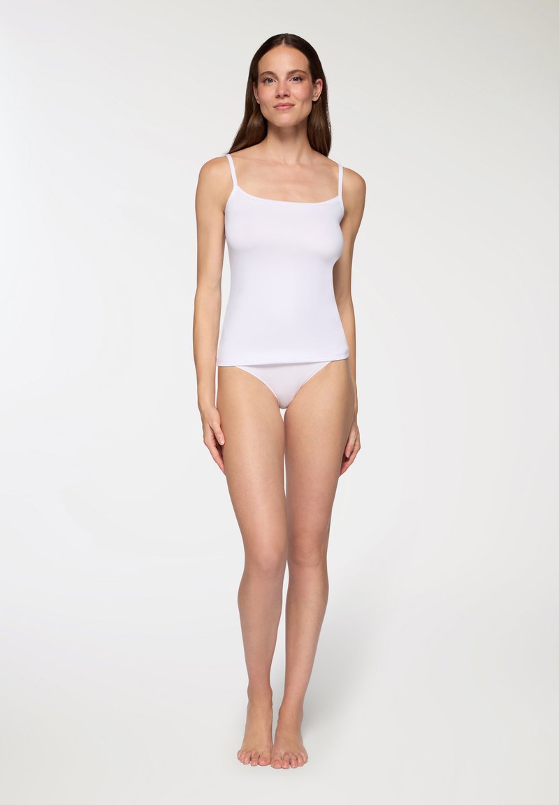 Top bianco senza maniche con spalline sottili e un design aderente, abbinato a biancheria intima bianca coordinata. Tessuto morbido e liscio con texture minima.