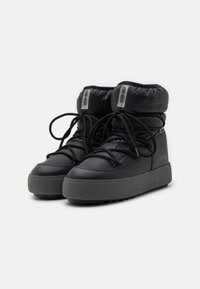 Schwarze, gepolsterte Knöchelstiefel mit einer dicken grauen Gummisohle, die verstellbare schwarze Schnürsenkel und geprägtes Branding an den Seiten haben.