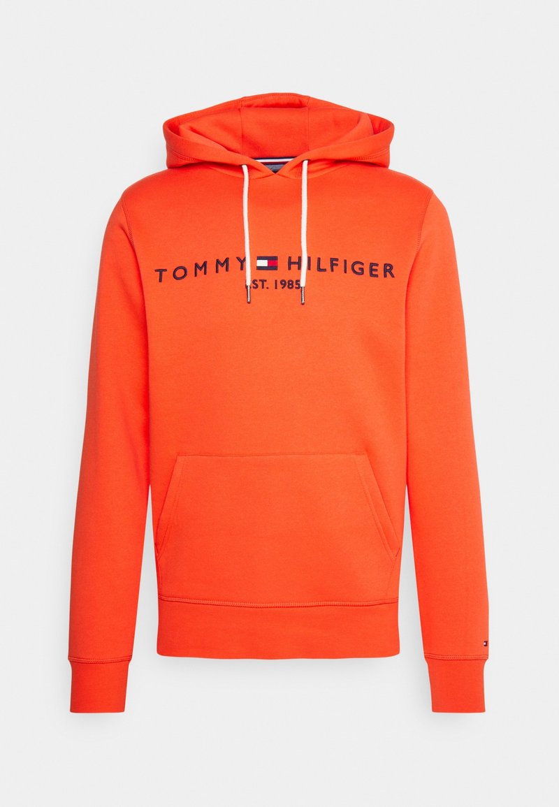 Sudadera naranja con bolsillo frontal, capucha con cordón y texto del logo en azul marino. Presenta puños y dobladillo acanalados, hecha de una tela suave.