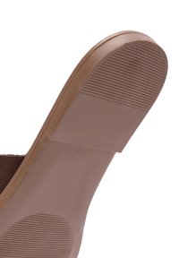 Semelle de chaussure marron avec surface lisse et zones antidérapantes texturées au talon et à la pointe, conçue pour l'adhérence et la durabilité.