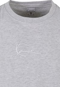 Gray cotton t-shirt with a round neckline and embroidered white logo. The fabric has a subtle texture and a relaxed fit.