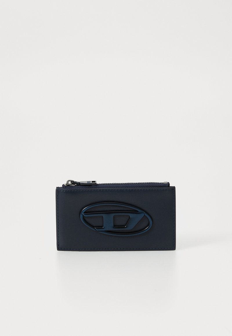 Navy leather wallet with a zip closure, featuring an oval logo accent. Smooth texture and rectangular shape for streamlined design.