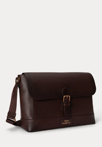 Σκούρα καφέ δερμάτινη τσάντα ταχυδρόμου με καπάκι, κλείσιμο με πόρπη, ρυθμιζόμενο ιμάντα ώμου και λογότυπο Polo Ralph Lauren στο μπροστινό μέρος.