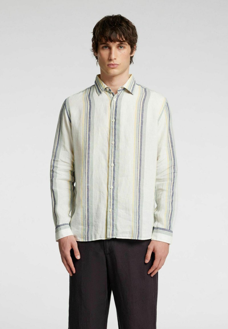 Camicetta chiara con bottoni realizzata in lino. Presenta righe verticali in grigio, giallo e blu, con maniche lunghe e colletto.