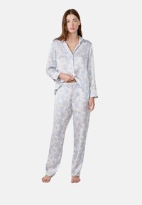 Lichtblauwe pyjama set met bloemendessin, gemaakt van zachte stof; langetermijnsluiting met knopen en bijpassende broek met trekkoord en elastische taille.