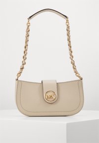 Sac à main en cuir beige avec une forme incurvée, une bandoulière en chaîne dorée et un fermoir à logo rond. Il présente des détails cousus et une texture lisse.