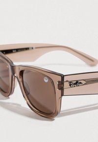 Ray-Ban sunglasses with transparent brown frame, brown tinted lenses, and logo detail. Square shape with distinctive side accents.