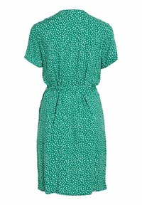 Robe verte longueur genou avec motif de points blancs irréguliers, manches courtes, taille cintrée et détail froncé dans le dos.