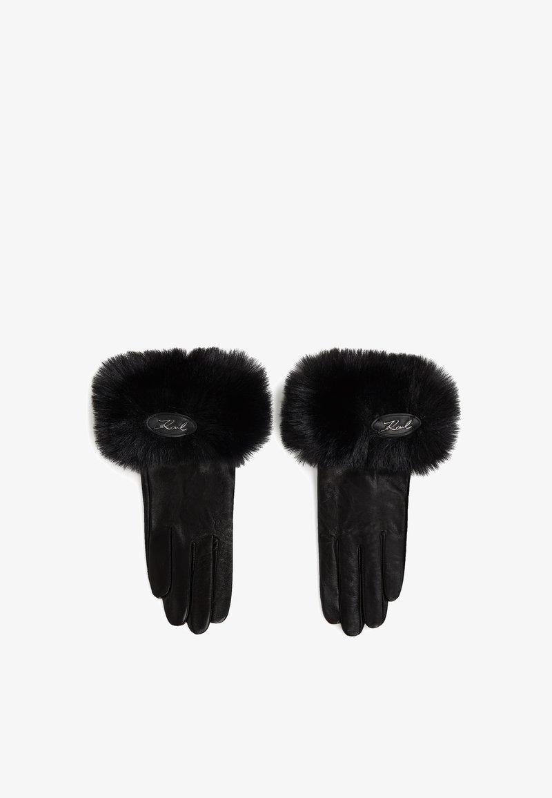 Luvas de couro preto com um punho em pelúcia preta sintética. Apresenta um patch oval com logotipo no punho. Textura suave com forma estruturada.