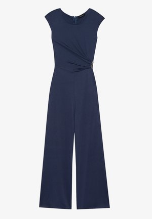 Combinaison bleu marine avec un corsage ajusté, des manches courtes et une coupe ample. Comprend un détail à l'avant en torsion et une fermeture éclair au dos.