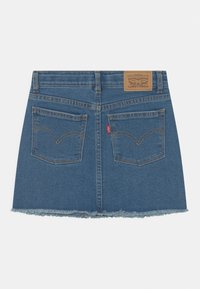 Jeansminikjol i ljusblått, med fransad fåll, två bakfickor med böjd söm och en brun läderlapp vid midjebandet.