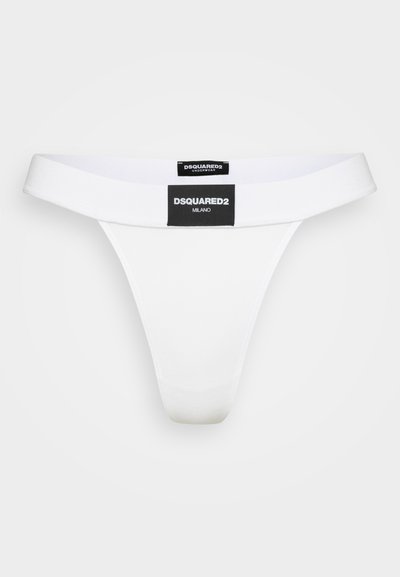 White thong underwear with a contrasting black branded label at the waistband, made of smooth fabric and featuring a minimalist design.