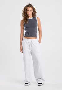 Gray sleeveless top with light blue trim, paired with loose-fitting gray sweatpants. The outfit is made from soft, comfortable fabric.