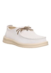 Scarpe in suede bianco con punta arrotondata, dettagli cuciti e lacci beige, caratterizzate da una superficie testurizzata e suola in gomma per una buona aderenza.