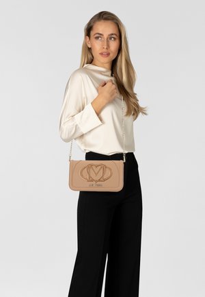 Beige Kunstleder Umhängetasche mit geprägtem Logo, Kettenriemen und rechteckiger Form. Glatte Textur und dekorative Akzent-Details.