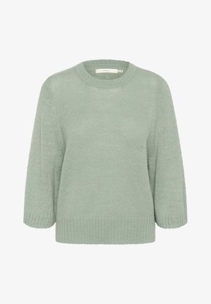 Minttu vihreä neulepaita, joka on valmistettu teksturoidusta kankaasta. Paita on pyöreällä kaula-aukolla, kolmanneksen pituisilla hihoilla sekä ribbireunuksilla hihansuissa ja helmassa.