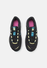 Sorte sportsko med mesh-overdel, gule og turkise accenter, rund tå, snøresystem og pink inderforing. Hvid sål.