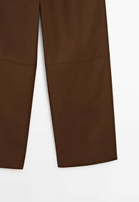 Pantalon marron à jambes larges avec un détail de couture au-dessus des genoux, montré de la mi-cuisse à l'ourlet sur fond blanc.
