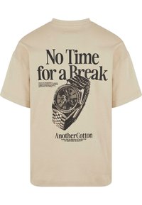Beige bomulds t-shirt med trykt tekst "No Time for a Break" og et monokromt ur-graphic på bagsiden. Løs pasform, korte ærmer.