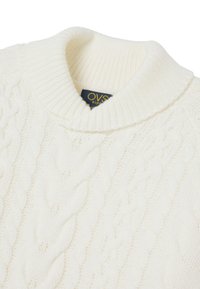 Suéter blanco de punto que presenta un patrón de trenzado, cuello acanalado y etiqueta interior con el nombre de la marca "OVS Kids". Textura suave y diseño ligero.