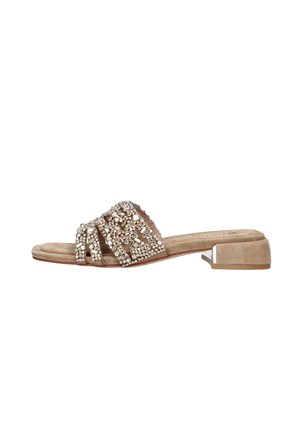 Sandalo beige in camoscio con tacco basso e ampi cinturini decorati con gruppi di strass scintillanti.