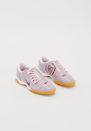 Pair of pink Nike indoor soccer shoes with gum soles, laces, and branding, including "90" on the side.