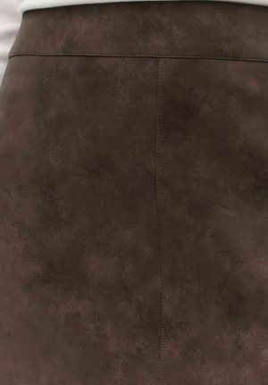 Brauner Kunstlederrock mit glatter Textur, der ein einfaches Design aufweist und sichtbare Nähte entlang der Seitennaht hat.