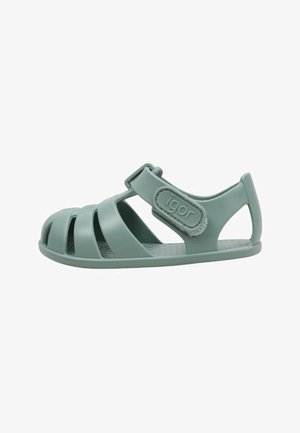 Sandale en caoutchouc verte à bout fermé pour enfant avec bride réglable et logo "igor" sur le côté, présentée sur fond blanc.