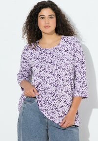 Fioletowa koszula w wzory z rękawami do łokcia, ozdobiona małymi białymi i czarnymi kropkami, z zaokrąglonym dekoltem i luźnym krojem.