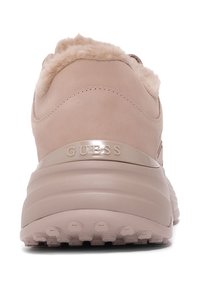 Różowe trampki z puszystym futrzanym kołnierzem, gładkim wykończeniem z zamszu i gumową podeszwą. Na pięcie znajduje się błyszczące logo "GUESS".