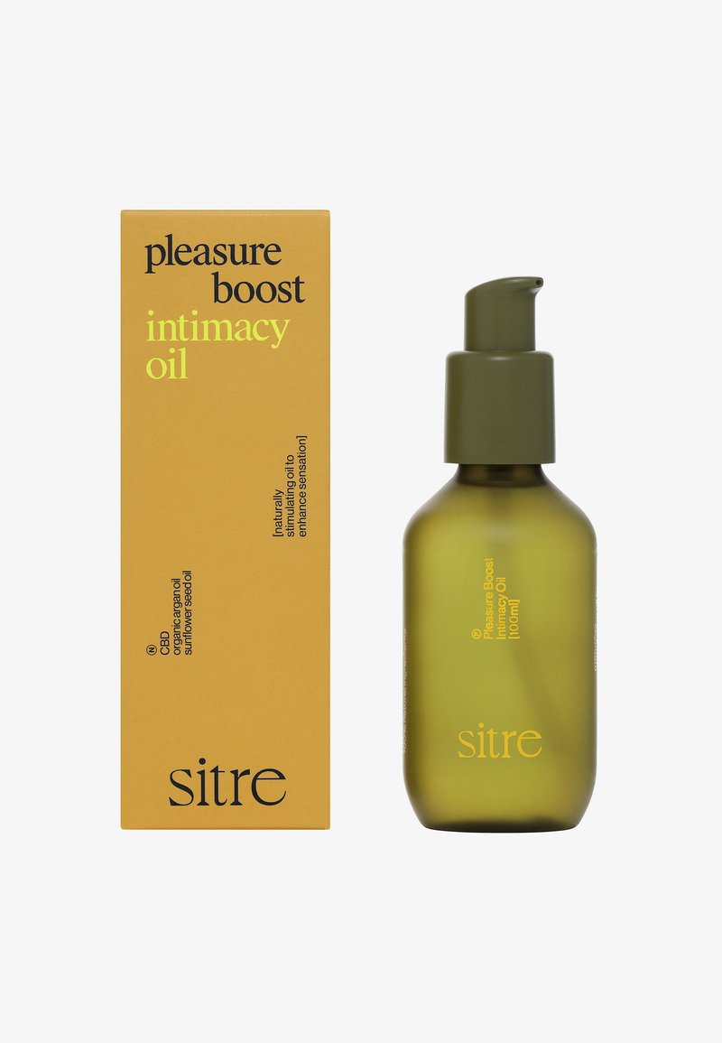 Sitre Pleasure Boost intimitetsolie i grøn pumpeflaske ved siden af gul emballage med produkt- og ingredienstekst.