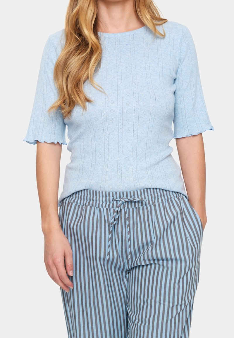 Ljusblå kortärmad topp med ribbad textur och vågig nederkant, tillsammans med grå och ljusblå randiga byxor med elastisk midja.