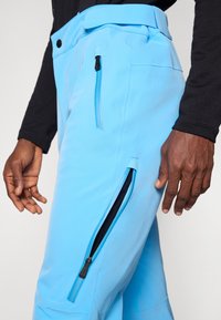 Ljusblå cargobyxor i ett stretchigt tyg, med två sidogångjärn, en slät yta och en bred midjeband för justerbar passform.