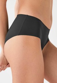 Zwarte hipster onderbroek met een naadloos ontwerp en een soepele textuur, voorzien van een hoge beenopening en een subtiele stikseldetail langs de tailleband.