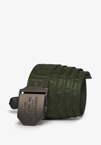 Groene geweven stoffen riem met een textuurpatroon, voorzien van een donkere metalen gesp die is gegraveerd met merk- en maatdetails.