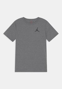 Maglietta in cotone grigia con scollatura a girocollo. Presenta un logo Jordan nero sul lato sinistro del petto. Maniche corte e vestibilità standard.