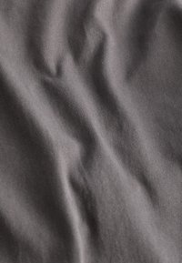 Gray fabric with a smooth texture and subtle crease patterns, showcasing a soft, woven structure.