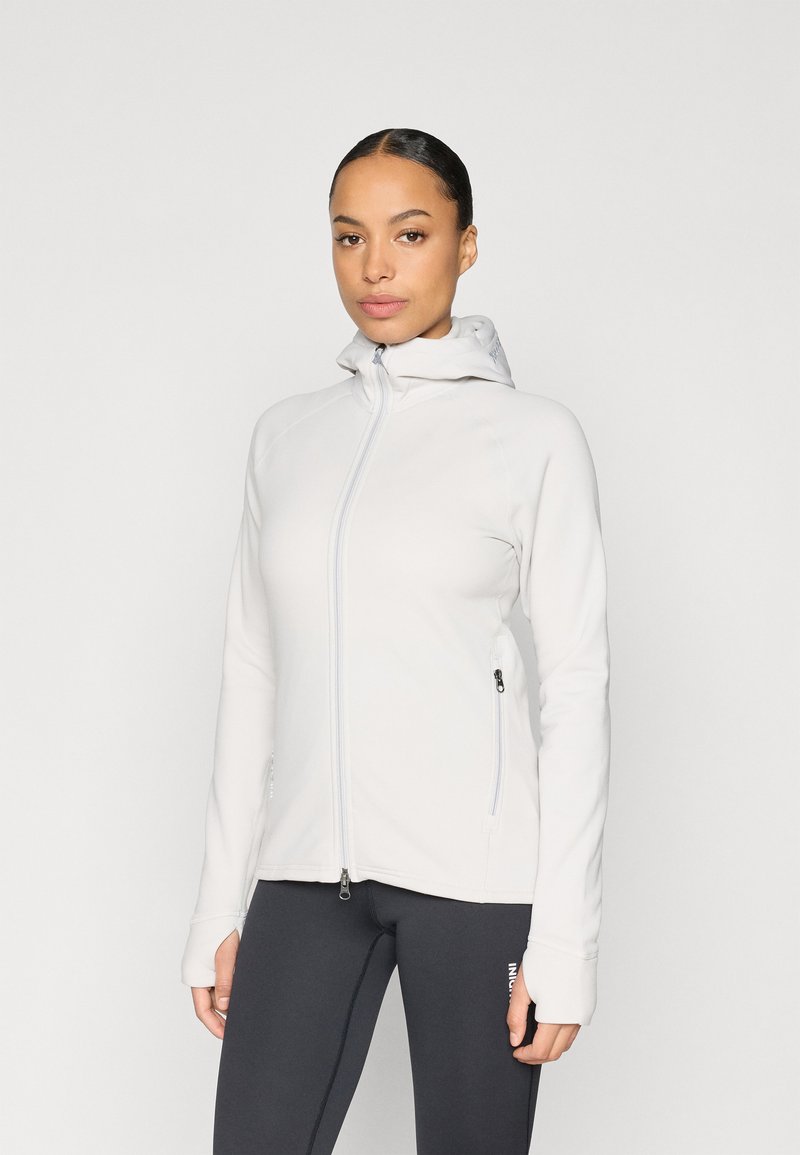 Hellgraue Jacke mit Reißverschluss und Kapuze, aus glattem, dehnbarem Stoff; verfügt über Seitentaschen und Daumenlöcher an den Bündchen.