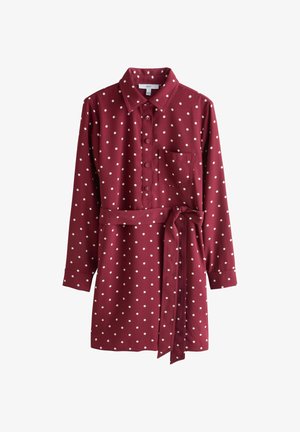Hnedá košeľová šaty vyrobené z hladkej tkaniny s bielymi bodkami, s gombíkovou prednou časťou, dlhými rukávmi, vreckom na hrudi a opaskom na zaväzovanie v páse.
