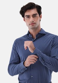Navyblau gestreiftes Hemd mit Button-Down-Kragen und langen Ärmeln. Verfügt über schmale weiße Streifen und eine glatte, polierte Stoffoberfläche.