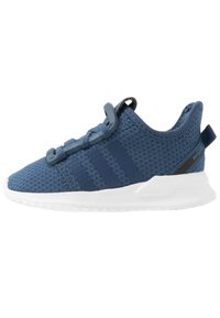 Zapatillas deportivas azules con parte superior de malla, suela de goma y tres líneas oscuras en el costado. Presenta un diseño texturizado y una lengüeta en el talón.