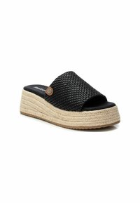 Sandalia deslizante negra tejida con una suela media de yute estilo espadrille y suela de goma, que presenta una puntera redondeada y un pequeño acento metálico.