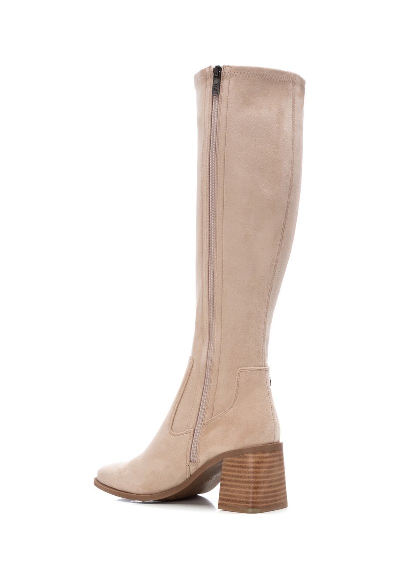 Beżowy zamszowy botek do kolan z bocznym zamkiem, w kształcie migdała i z drewnianym obcasem warstwowym, ozdobionym poziomymi rowkami.